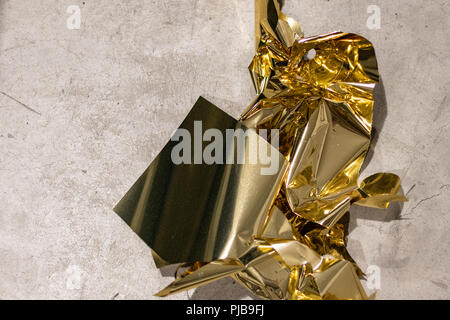 Golden sfridi sul pavimento di tondi per cemento dopo una massiccia sessione di taglio per le decorazioni di Natale. Foto Stock