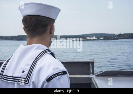 Maine (Luglio 2, 2018) un marinaio assegnato all'Arleigh Burke class guidato-missile destroyer USS McFaul (DDG 74) mans le rotaie durante un mare e evoluzione di ancoraggio. McFaul sta attualmente conducendo un porto di scalo in Eastport, Maine, per partecipare al 4 luglio celebrazione. Foto Stock