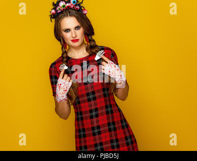 Colorato halloween. giovane donna in stile messicano costume di halloween isolato su giallo Foto Stock