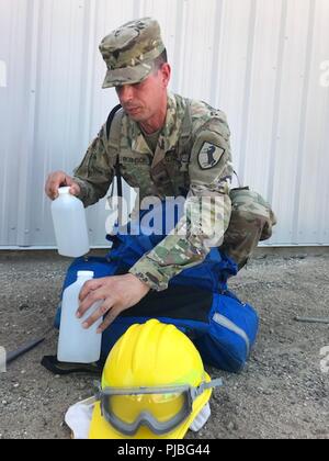 Stati Uniti Army Spc. Keevan Robinson della California esercito nazionale della guardia campo 144reggimento di artiglieria, centesimo comando di truppa, quarantesimo divisione di fanteria, rimanenze il suo kit antincendio luglio 12 a Camp Roberts, California, come più di 500 guardie stanno preparando per terra durante le missioni della California stagione wildfire. Kit individuali contengono acqua contenitori, utensili e dispositivi di protezione personale come nome di giacche, guanti e caschi. Foto Stock