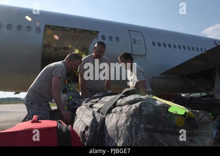 Stati Uniti Avieri del 169Fighter Wing della Carolina del Sud Air National Guard a McEntire comune di Guardia Nazionale Base, Carolina del Sud, caricare i bagagli su un civile-contratti grandi velivoli da trasporto, luglio 11, 2018. La Carolina del Sud Air National Guard's 169Fighter Wing è la distribuzione di quasi 300 aviatori e circa una dozzina di F-16 Blocco 52 Fighting Falcon jet da combattimento per l'aria 407 Gruppo Expeditionary nel sud-ovest Asia a sostegno di un'Aria forza expeditionary rotazione. Foto Stock