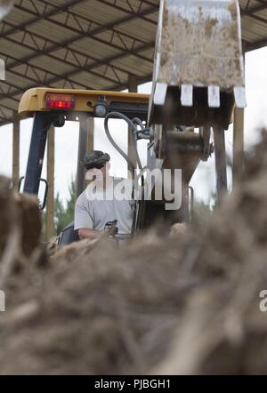 Stati Uniti Air Force Tech. Sgt. Thomas Hewes, membro dell'166Ingegnere Civile Squadron, Delaware Air National Guard, opera un retroescavatore per rimuovere eccesso di legno da una pila per la masterizzazione, come parte di una fase di costruzione di Camp Kamassa in Crystal molle, Mississippi, luglio 11, 2018. Camp Kamassa saranno stati prima completamente accessibile ai portatori di handicap, anno camp agevolazione per gli adulti e per i bambini con bisogni speciali, che viene costruito su 326 acri capeggiate dal Dipartimento della Difesa prontezza innovativo programma di formazione. Foto Stock
