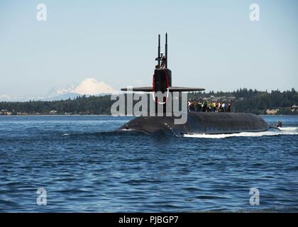 PUGET SOUND, nello Stato di Washington (12 luglio 2018) i membri di Big Red Sub Club ride la Ohio-class missile balistico sommergibile USS Nebraska (SSBN 739) attraverso il canale del cofano come la barca ritorna a casa a base navale Kitsap-Bangor seguendo il suo primo pattugliamento strategico fin dal 2013. Il Nebraska ha recentemente completato un 41-mese progettato il rifornimento di revisione, che consentirà di estendere la vita del sommergibile per altri vent'anni. Foto Stock