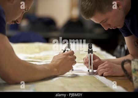 Membri della Stazione della Guardia Costiera Juneau, Alaska, tracciare il percorso migliore per Sitka, Alaska, per un prossimo viaggio Luglio 10, 2017. Saper tracciare su un grafico è un requisito per diventare pienamente qualificato boatcrew. Stati Uniti Coast Guard Foto Stock