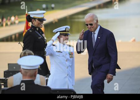 Ex Vice Presidente degli Stati Uniti, Joe Biden, saluta l'elemento di hosting come egli si prepara a prendere il suo posto come ospite d'onore durante un martedì tramonto Parade presso il Lincoln Memorial, Washington D.C., 10 luglio 2018. Biden è stato ospite di onore e di hosting ufficiale è stato il personale giudice avvocato al comandante del Marine Corps, il Mag. Gen. John R. Ewers Jr. Foto Stock