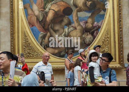 I visitatori di fronte al dipinto 'Jupiter Hockey irlandese Thunderbolts a vizi' dal Rinascimento italiano pittore veronese (1556) visualizzato nel museo del Louvre a Parigi, Francia. Foto Stock