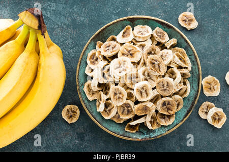Banane essiccate in chip e banane fresche Foto Stock