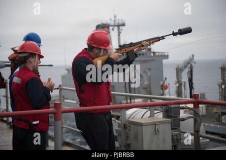 Oceano Pacifico (14 luglio 2018) da bombardieri Mate 3° di classe Matthew Parker, da Portland, Tennessee, assegnato al dock di anfibio sbarco nave USS harpers Ferry (LSD 49), spara un colpo la linea per il rifornimento della flotta USNS oliatore Yukon (T-AO 202) a condurre a una ricostituzione in mare, 14 luglio, a sostegno del cerchione del Pacifico (RIMPAC) esercizio. Venticinque nazioni, 46 navi, cinque sommergibili, circa 200 aerei e 25.000 personale partecipano RIMPAC dal 27 giugno al 2 agosto in e intorno alle Isole Hawaii e la California del Sud. Il più grande del mondo marittimo internazionale esercitazione RIMPAC pro Foto Stock