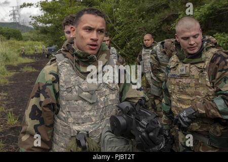 Airman 1. Classe Ramon Dickerson, sinistra, 374 Forza squadrone di supporto addetto postale, fate un profondo respiro dopo aver sperimentato di gas CS a bracci combinato Training Center Camp Fuji, Giappone, luglio 6, 2018. Oltre 60 Yokota Gli aviatori hanno imparato ad avere fiducia in loro apparecchiature entrando nella maschera a gas della camera di fiducia. Foto Stock