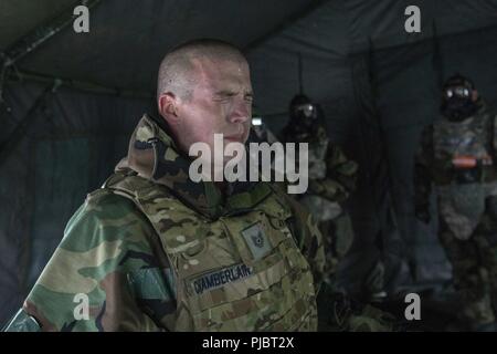 Tech. Sgt. Aaron Chamberlain, 374 Gruppo manutenzione motore base manager, è esposto al gas CS all'interno della maschera a gas della camera di fiducia a bracci combinato Training Center Camp Fuji, Giappone, luglio 6, 2018. Oltre 60 Yokota Gli aviatori hanno imparato ad avere fiducia in loro apparecchiature entrando nella maschera a gas della camera di fiducia. Foto Stock