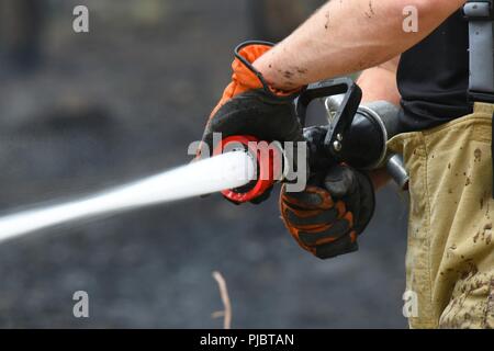 Un membro della Suffolk fuoco e il servizio di soccorso combatte contro un incendio vicino a Brandon, Inghilterra, 13 luglio 2018. Il Suffolk fuoco e il servizio di soccorso ha ricevuto il sostegno della 48th ingegnere civile Squadron at Royal Air Force Lakenheath e altri servizi di emergenza nell'area locale. Foto Stock