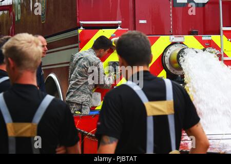 Un aviatore assegnato alla 48th ingegnere civile Squadrone al 48th Fighter Wing opera una navetta di serbatoio di acqua a sostegno di Suffolk fuoco e il servizio di soccorso dei membri del team come essi contro un incendio vicino a Brandon, Inghilterra, 13 luglio 2018. La navetta serbatoio di acqua è in grado di trasportare fino a 15.000 litri di acqua in una volta e viene utilizzato in aree in cui l'acqua non può essere facilmente accessibili. Foto Stock