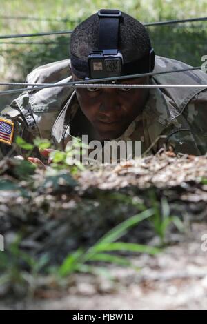 Stati Uniti Il personale dell'esercito Sgt. Duane Butler esegue la bassa crawl evento presso il corso di fiducia durante l'esercito Materiel del comando guerriero migliore concorrenza 9-11 luglio 2018, presso il Camp Atterbury, Indiana. Durante i tre giorni di gara, i soldati sono stati testati su base e avanzate attività di guerriero e trapani, si trovano di fronte a sfide prova la loro forza fisica e mentale. Foto Stock