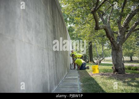 Volontari raddrizzare, livello e sostituire le pietre rotte al di fuori della Corte Columbarium 1 presso il Cimitero Nazionale di Arlington Arlington, Virginia, 16 luglio 2018. Oltre 400 volontari professionisti del paesaggio ha partecipato in Associazione Nazionale dei professionisti del paesaggio' xxii rinnovo annuale e ricordo evento presso il Cimitero Nazionale di Arlington. Volontari aerato turf, piantato fiori, di cui i tubi di irrigazione e illuminazione installata una protezione su diversi alberi. Foto Stock