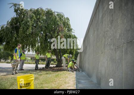 Volontari raddrizzare, livello e sostituire le pietre rotte al di fuori della Corte Columbarium 1 presso il Cimitero Nazionale di Arlington Arlington, Virginia, 16 luglio 2018. Oltre 400 volontari professionisti del paesaggio ha partecipato in Associazione Nazionale dei professionisti del paesaggio' xxii rinnovo annuale e ricordo evento presso il Cimitero Nazionale di Arlington. Volontari aerato turf, piantato fiori, di cui i tubi di irrigazione e illuminazione installata una protezione su diversi alberi. Foto Stock