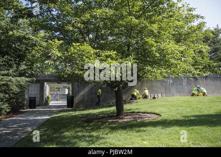 Volontari raddrizzare, livello e sostituire le pietre rotte al di fuori della Corte Columbarium 1 presso il Cimitero Nazionale di Arlington Arlington, Virginia, 16 luglio 2018. Oltre 400 volontari professionisti del paesaggio ha partecipato in Associazione Nazionale dei professionisti del paesaggio' xxii rinnovo annuale e ricordo evento presso il Cimitero Nazionale di Arlington. Volontari aerato turf, piantato fiori, di cui i tubi di irrigazione e illuminazione installata una protezione su diversi alberi. Foto Stock