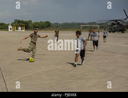 Stati Uniti Il personale marino Sgt. Jesse Braswell, l'elemento di comando azienda sergente gunnery con scopi speciali Air-Ground Marine Task Force - Comando Sud, si prepara a dare un calcio a un pallone durante una partita amichevole di calcio con il Guatemala militari in Flores, Guatemala, 4 luglio 2018. I marines e i marinai di SPMAGTF-SC ha celebrato il Giorno di indipendenza con il militare guatemalteco di creare e rafforzare i legami tra la nazione partner di forze militari. I marines e i marinai di SPMAGTF-SC sono in conduzione la cooperazione in materia di sicurezza la formazione e i progetti di ingegneria a fianco di partner nazione forze militari nel centro Foto Stock