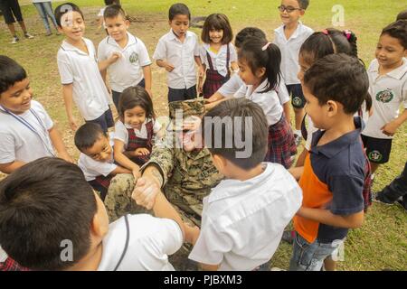 Stati Uniti Il personale marino Sgt. Jesse Braswell, l'elemento di comando azienda sergente gunnery con scopi speciali Air-Ground Marine Task Force - Comando Sud, gioca con locale bambini guatemaltechi nel corso di un sondaggio del sito presso una scuola Marines sarà rimessa a nuovo in Flores, Guatemala, Luglio 9, 2018. I marines e i marinai di SPMAGTF-SC sono in conduzione la cooperazione in materia di sicurezza la formazione e i progetti di ingegneria a fianco di partner nazione le forze militari in America Centrale e America del Sud. L'unità è anche in standby per fornire assistenza umanitaria e di soccorso in caso di catastrofe in caso di un uragano o altre situazioni di emergenza in Foto Stock