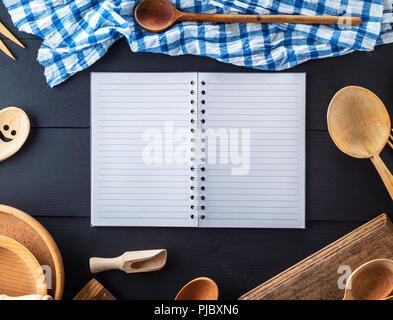 Vuoto notebook aperti in linea e cucina in legno accessori, concetto di ricetta Foto Stock