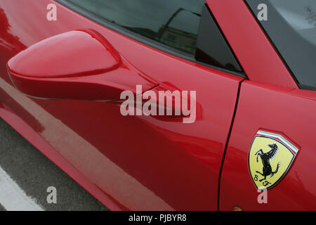 Primo piano dello specchio parafango e iconico badge su un rosso Ferrari 458 Spider in Bawtry, nello Yorkshire, Inghilterra Foto Stock