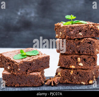 Pila di cotto in pezzi quadrati di cioccolato torta brownie con noci, close up Foto Stock