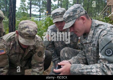 Stati Uniti La riserva di esercito soldato, SPC. Brandon Shreve, una purificazione acqua supervisore con la 326Quartermaster Company, basato a Newcastle, Pennsylvania allenatori del suo team su acqua di apparecchiature di test durante il Quartermaster Logistica liquido di esercizio 2018 a Fort Bragg, North Carolina, 14-28 luglio, 2018. QLLEX è un esercizio che garantisce l'America dell'esercito di unità di riserva e soldati sono addestrati e pronti per stabilire la depurazione delle acque, lo stoccaggio, la distribuzione e le operazioni del carburante al fine di fornire la vita sostenere acqua e carburante. Foto Stock