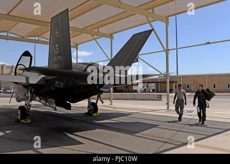 Un 61st Fighter Squadron passeggiate pilota con un 61st Manutenzione aeromobili manutentore di unità a un F-35un fulmine II per una formazione di transizione sortie Luglio 18, 2018 a Luke Air Force Base, Ariz. La sortie coinvolto quattro istruttore formazione piloti di quattro studenti sulla base delle manovre di volo. Foto Stock