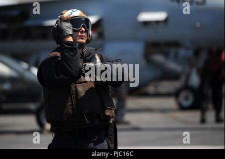 Oceano atlantico (17 luglio 2018) di aviazione del macchinista Mate Airman Jeremy Bellant segnali ad un'F/A-18F Super Hornet sul ponte di volo a bordo della Nimitz-class portaerei USS Harry Truman (CVN 75). Harry Truman è attualmente implementata come parte di una costante rotazione delle forze degli Stati Uniti sostenere le operazioni di sicurezza marittima nelle acque internazionali in tutto il mondo. Foto Stock