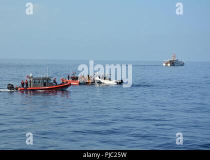 Una stazione della Guardia Costiera Key West 33-piede scopo speciale Craft-Applicazione della Legge boatcrew, un guardacoste Isacco Mayo boatcrew, e una delle dogane e della protezione delle frontiere aria e operazioni Marine unità marine intercettare un 26-piede recipiente rustico in Florida Straits Martedì, luglio 17, 2018 con 28 emigranti cubani a bordo. Il 28 migranti sono stati rimpatriati a Cuba Venerdì 20 Luglio, 2018. Foto Stock