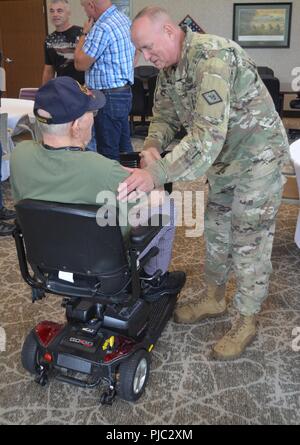 Il comando Sgt. Il Mag. Steven Veazey, Senior leader arruolato, Arkansas Guardia nazionale, scuote la mano del maestro in pensione Sgt. Denman Wolfe, una guerra mondiale II veterano, in Arkansas veterani Home in North Little Rock, Arkansas, luglio 18, 2018. Foto Stock