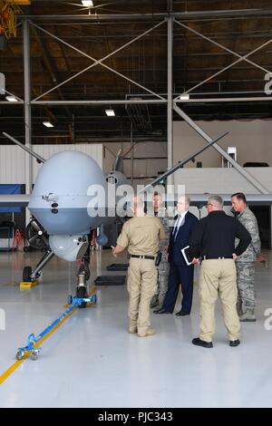 Dominic Pohl, XXV Air Force direttore esecutivo, centro, impara più circa il MQ-9 Raptor utilizzato da delle dogane e della protezione delle frontiere Luglio 20, 2018 il Grand Forks Air Force Base in North Dakota. David Fulcher, il CBP direttore delle operazioni, sinistra, condivisa con Pohl le specifiche dei velivoli senza pilota, per includere i raggi infrarossi di imaging e di lunga durata, abilità. Foto Stock