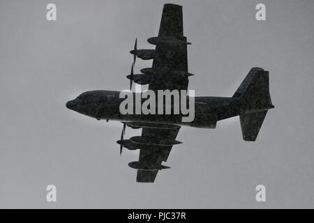 Un U.S. Marine Corps C-130J Super Hercules cargo aereo con l'antenna Marine Refueler squadrone di trasporto (VMGR) 152 di Okinawa in Giappone vola attraverso la pioggia come si passa sopra il Malemute drop zone, luglio 16, 2018 a base comune Elmendorf-Richardson, Alaska. La formazione era parte di un 12 giorni di esercizio chiamato Kodiak macis che incorporati C-130J Super Hercules aerei cargo appartenente all'antenna Marine Refueler squadrone di trasporto (VMGR) 152 e marines dal 3d TSB, CLR-3, 3d MLG. L'acqua è stato utilizzato per simulare il pompaggio del combustibile. Foto Stock