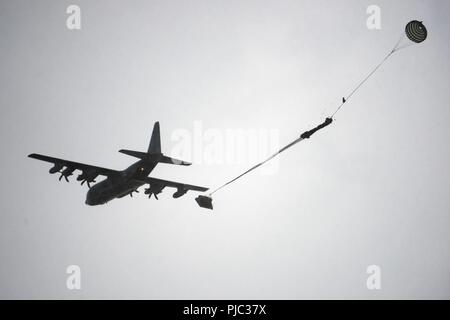 Un U.S. Marine Corps C-130J Super Hercules cargo aereo con l'antenna Marine Refueler squadrone di trasporto (VMGR) 152 di Okinawa in Giappone scende attrezzature pesanti su Malemute drop zone, luglio 16, 2018 a base comune Elmendorf-Richardson, Alaska. La formazione era parte di un 12 giorni di esercizio chiamato Kodiak macis che incorporati C-130J Super Hercules aerei cargo appartenente all'antenna Marine Refueler squadrone di trasporto (VMGR) 152 e marines dal 3d TSB, CLR-3, 3d MLG. L'acqua è stato utilizzato per simulare il pompaggio del combustibile. Foto Stock