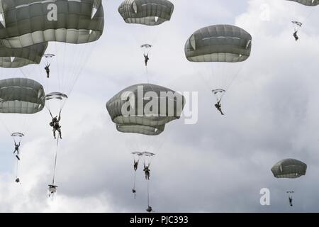 Paracadutisti da U.S. Esercito dell Alaska quarta brigata di fanteria combattere Team (airborne), XXV divisione di fanteria scendono verso Malemute zona di caduta sulla giunzione base Elmendorf-Richardson, Alaska, 17 luglio 2018. Più di 400 soldati paracadutato come parte di un campo esercitazione, l'esecuzione di movimenti tattici e impostazione di posizioni difensive durante l'esecuzione di un aerodromo assalto. Foto Stock