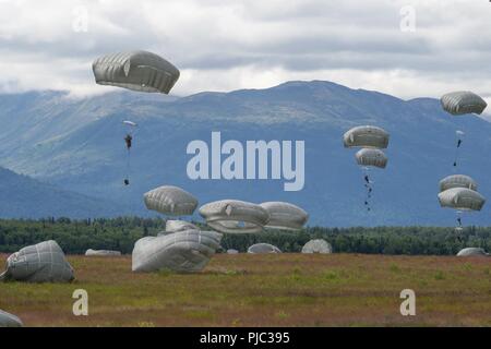 Paracadutisti da U.S. Esercito dell Alaska quarta brigata di fanteria combattere Team (airborne), XXV divisione di fanteria scendono verso Malemute zona di caduta sulla giunzione base Elmendorf-Richardson, Alaska, 17 luglio 2018. Più di 400 soldati paracadutato come parte di un campo esercitazione, l'esecuzione di movimenti tattici e impostazione di posizioni difensive durante l'esecuzione di un aerodromo assalto. Foto Stock