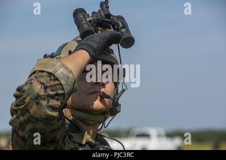 Un U.S. Marine con il secondo battaglione di ricognizione, seconda divisione Marine, esegue la scansione del cielo per una tattica di rialimentazione caduta durante un rifornimento di esercizio di recupero di Camp Lejeune, N.C., 11 luglio, 2018. La formazione ha migliorato il Marines' abilità per tatticamente recuperare le forniture e le attrezzature in preparazione per il potenziale del mondo reale in missioni di ambienti austeri. Foto Stock