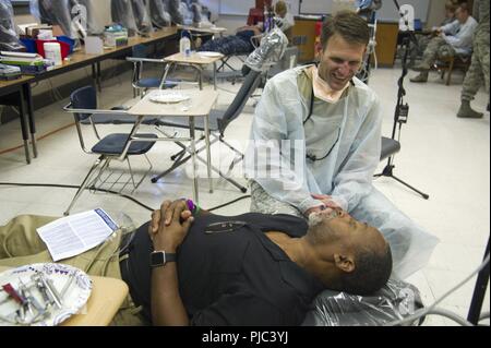 Stati Uniti Air Force Il Mag. Dwayne Gentry un dentista per Hill Air Force Base in Utah, colloqui con un paziente locale presso la Thomson, Ga., sito sulla cura dentale Luglio 10, 2018 durante la East Central Georgia disponibilità innovative di formazione. Un IRT fornisce hands-on del mondo reale, formazione per migliorare la disponibilità e la capacità di sopravvivenza per servicemembers in complessi ambienti di emergenza mentre che fornisce servizi essenziali per la comunità americana. Foto Stock