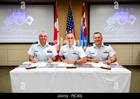 Canadian Brig. Gen. Sylvain Menard (centro), Stati Uniti continentali North American Aerospace Defense Regione (CONR) vice comandante, presiede il canadese distacco Base comune corda Lewis-Mccambiamento di comando. Lt. Col. Michael Fawcett (sinistra) assume il comando dal comandante uscente, Lt. Col. Matteo Wappler (destra), durante le cerimonie di firma del cambiamento di comando scorre Luglio 10, 2018. Foto Stock