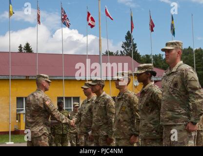 Yavoriv, Ucraina - Classe 703-2018 Base Corso di Leadership istruito dal settimo esercito Comando formazione sottufficiali completare una cerimonia di laurea a Yavoriv Combat Training Center (CTC) Luglio 11. Il 5 istruttori sono stati ciascuno dato un premio e sfida moneta da 27 della brigata di fanteria combattere Team (avanti) Command Sgt. Il Mag. Marc Maynard di Rochester, NY, per la loro professionalità e la esecuzione del loro corso. Foto Stock