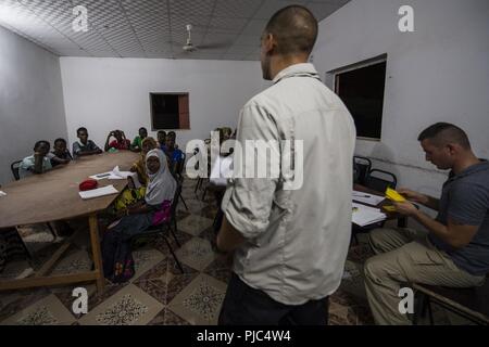 Un U.S. Soldato dell'esercito assegnato all'affari civili battaglione, spiega la lezione per gli studenti del Gibuti durante la classe inglese in Tadjourah, Gibuti, 10 luglio 2018. Il Affari Civili Lead del team inglese di gruppi di discussione in tutta la combinazione di area per operazioni congiunte, a rafforzare i legami locali nella regione fornendo al contempo opportunità per i bambini di ampliare le loro conoscenze e competenze con la lingua inglese. Foto Stock