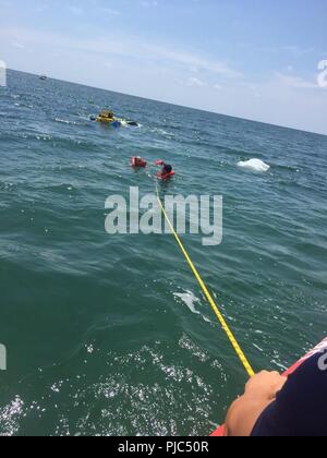 Una stazione della Guardia Costiera Islamorada 33-piede scopo speciale Craft-Applicazione della Legge boatcrew tirare due persone per la sicurezza Sabato, 14 Luglio 2018 da una barca capovolta vicino al porto di balene vicino a Islamorada, Florida. Due persone non hanno riportato lesioni. Stati Uniti Coast Guard Foto Stock