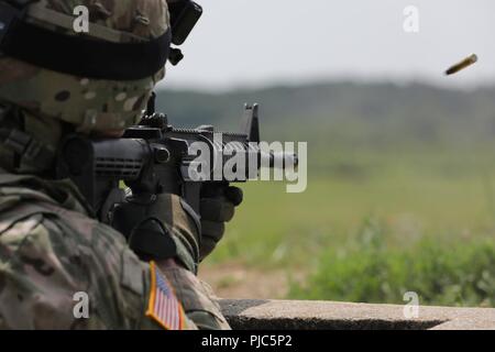 Stati Uniti Il personale dell'esercito Sgt. Duane Butler incendi di M4A1 carbine in corrispondenza di un intervallo durante l'esercito Materiel del comando guerriero migliore concorrenza 9-11 luglio 2018, presso il Camp Atterbury, Indiana. Durante i tre giorni di gara, i soldati sono stati testati su base e avanzate attività di guerriero e trapani, si trovano di fronte a sfide prova la loro forza fisica e mentale. Foto Stock