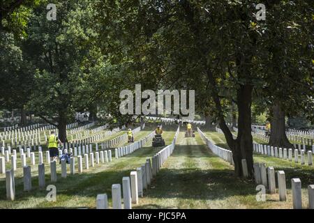 I volontari dell Associazione Nazionale dei professionisti del paesaggio (NALP) aerare la sezione 28 di Al Cimitero Nazionale di Arlington Arlington, Virginia, 16 luglio 2018. Oltre 400 volontari professionisti del paesaggio ha partecipato al NALP XXII del rinnovo annuale e ricordo evento presso il Cimitero Nazionale di Arlington. Volontari aerato turf, piantato fiori, di cui i tubi di irrigazione e illuminazione installata una protezione su diversi alberi. Foto Stock