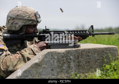 Stati Uniti Il personale dell'esercito Sgt. Duane Butler incendi di M4A1 carbine in corrispondenza di un intervallo durante l'esercito Materiel del comando guerriero migliore concorrenza 9-11 luglio 2018, presso il Camp Atterbury, Indiana. Durante i tre giorni di gara, i soldati sono stati testati su base e avanzate attività di guerriero e trapani, si trovano di fronte a sfide prova la loro forza fisica e mentale. Foto Stock