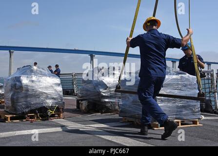 I membri dell'equipaggio dalla Guardacoste saldi preparare un pallet di cocaina sequestrata per essere scaricata a Tenth Avenue Terminale Marino, San Diego, 16 luglio 2018. Circa 7.800 chilogrammi di cocaina sequestrata in acque internazionali nell'Oceano Pacifico orientale dagli equipaggi delle frese saldi e Alert sono stati scaricati. Foto Stock