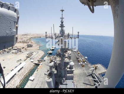 AQABA Giordania (9 luglio 2018) Il Wasp-classe assalto anfibio nave USS Iwo Jima (LHD 7) si trova sul lato del molo Aqaba Giordania. Iwo Jima è distribuito negli Stati Uniti Quinta Flotta area di operazioni a sostegno di operazioni navali per garantire stabilità marittimo e la sicurezza nella regione centrale di collegamento del Mediterraneo e del Pacifico attraverso l'Oceano Indiano occidentale e tre strategici punti di strozzatura. Foto Stock