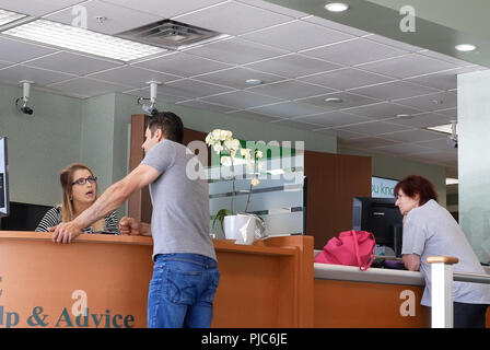 Coquitlam, BC, Canada - 14 Maggio 2018 : il movimento di persone che parlano al bancomat presso contatore di servizio all'interno di TD Bank Foto Stock