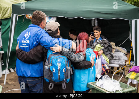 BERKASOVO, SERBIA - Settembre 27, 2015: i lavoratori dell'ACNUR, l'Agenzia delle Nazioni Unite per i rifugiati, scattare foto con un migrante al confine scommessa Foto Stock