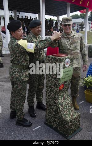 Brig. Gen. Datu Haji Rezuan bin Haji Omar, Commander, 1° brigata di fanteria esercito Malese, il Mag. Gen. Dato HJ Azlan bin Abu Rahman, capo di Stato Maggiore dell esercito, il comando del campo, West quartier generale, malese esercito e Col. Anthony Lieggi, Commander, 96a comando di truppa, Washington Esercito Nazionale Guardia, inserire un coltello cerimoniale per commemorare l inizio dell esercizio Keris sciopero, luglio 23, 2018. Esercizio Keris Strike è un esercizio di bilaterali tra la Malaysia e gli Stati Uniti, con un particolare accento sulla politica regionale di assistenza umanitaria e di disaster relief operations. Foto Stock