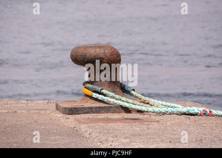 Foto di un metallo arrugginito bolard ormeggio per la grande nave Foto Stock